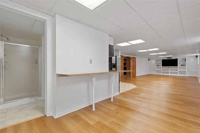 340 Old Scales Rd, South Franklin, PA 15301 - basement with built in shelves, a drop ceiling, stainless steel fridge, and light wood-style floors
