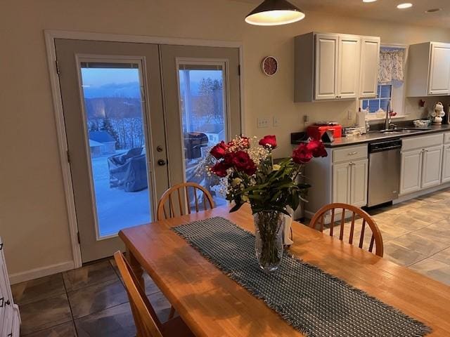 dining area featuring light tile patterned flooring, sink, and french doors