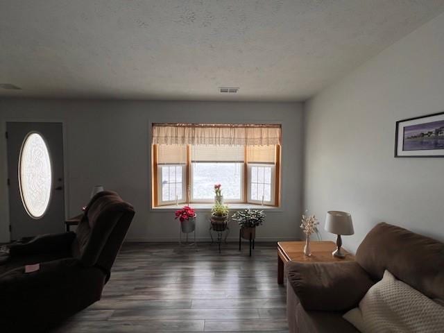 living room with dark hardwood / wood-style flooring and a textured ceiling