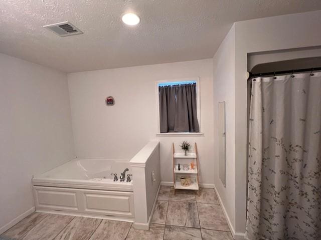 bathroom with plus walk in shower and a textured ceiling