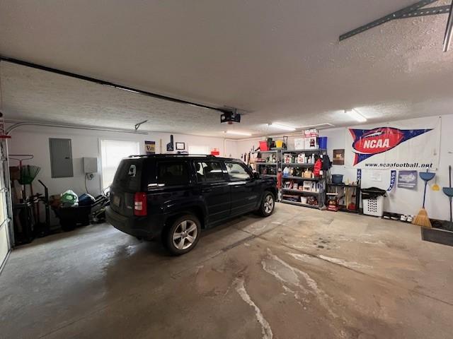 garage with a garage door opener and electric panel