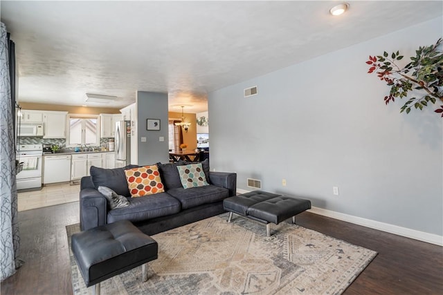 living room with dark wood-type flooring and sink