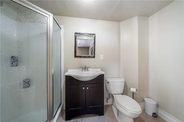 bathroom featuring vanity, a shower with door, toilet, and tile patterned floors