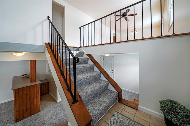 stairs with ceiling fan and tile patterned flooring