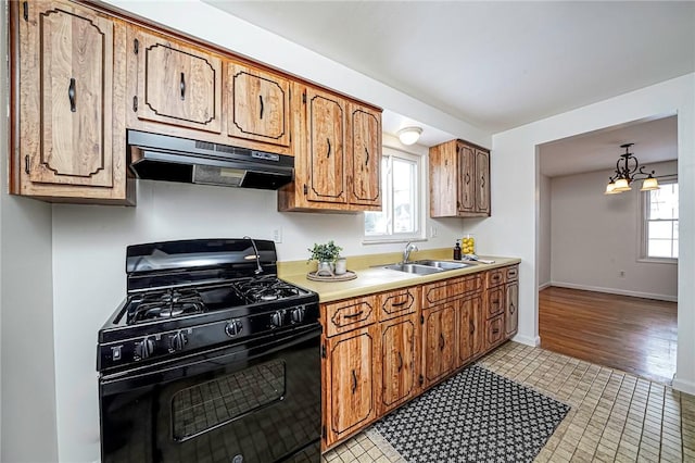 kitchen featuring sink, hanging light fixtures, gas stove, and a wealth of natural light