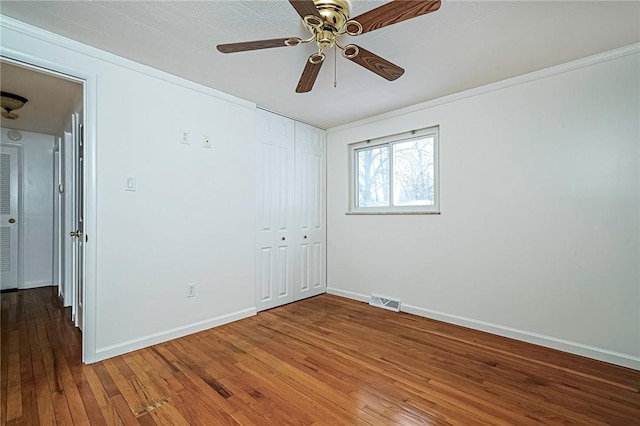 unfurnished room featuring ceiling fan, wood-type flooring, and crown molding