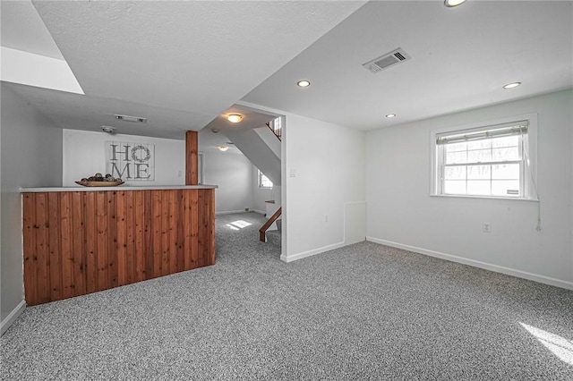 bonus room with carpet flooring and a textured ceiling