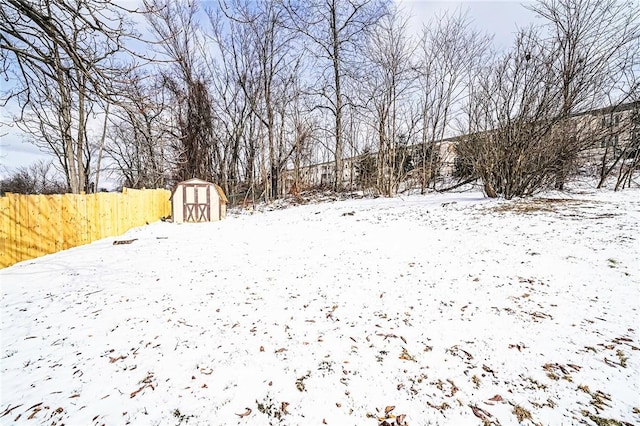 yard layered in snow with a storage unit