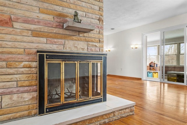 room details featuring a multi sided fireplace and wood-type flooring