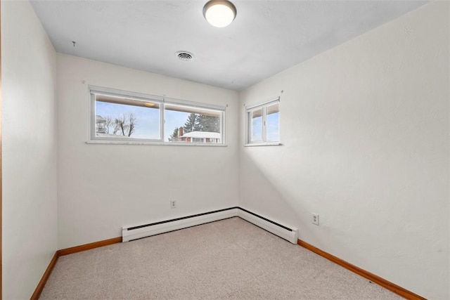 unfurnished room with a baseboard heating unit and carpet