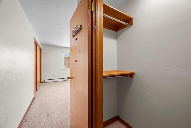 walk in closet with light carpet and a baseboard radiator