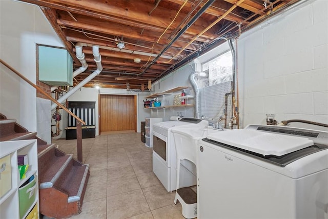 clothes washing area with separate washer and dryer and light tile patterned floors