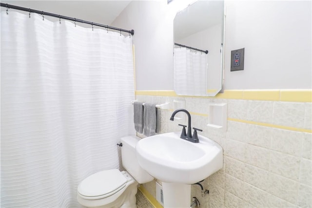 bathroom with tile walls, sink, and toilet