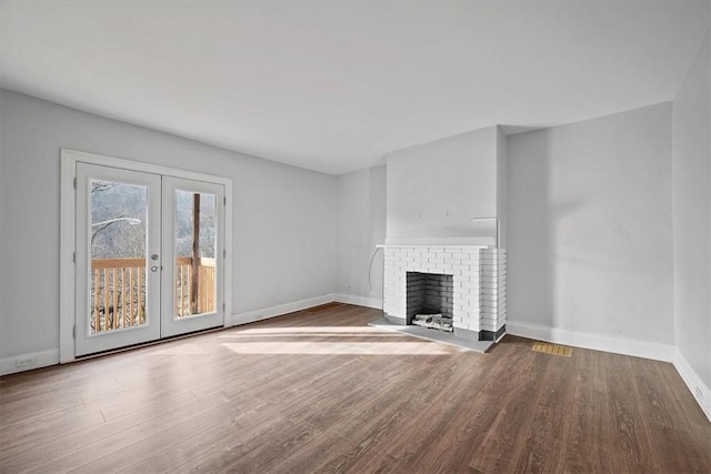 unfurnished living room with a fireplace, french doors, and hardwood / wood-style floors