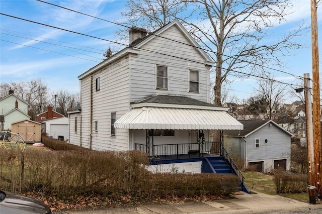 view of front of property with covered porch and a storage unit