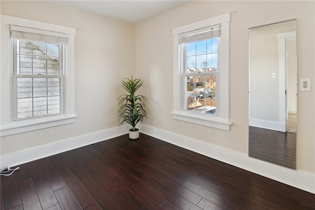 unfurnished room with wood-type flooring and baseboards