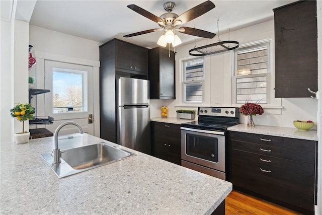 kitchen with stainless steel appliances, light countertops, a sink, and ceiling fan