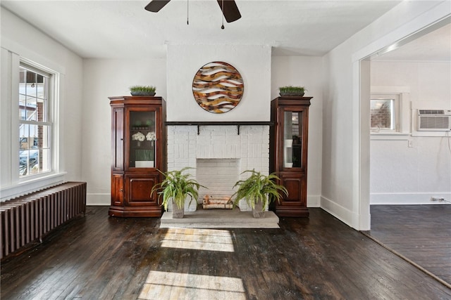 living area with radiator, a fireplace, baseboards, and dark wood-type flooring