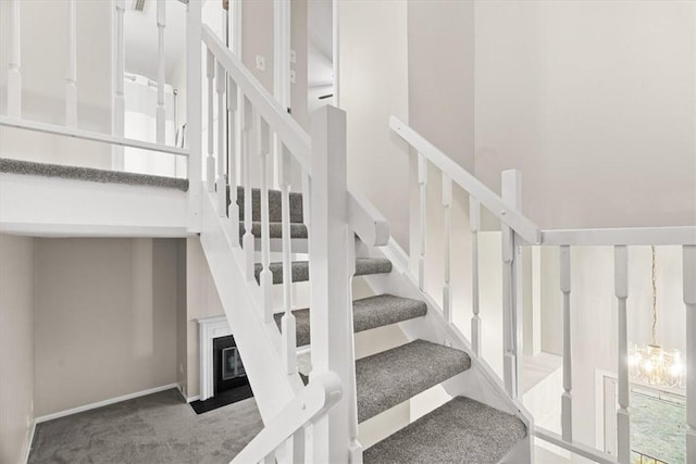 staircase featuring carpet floors and a towering ceiling