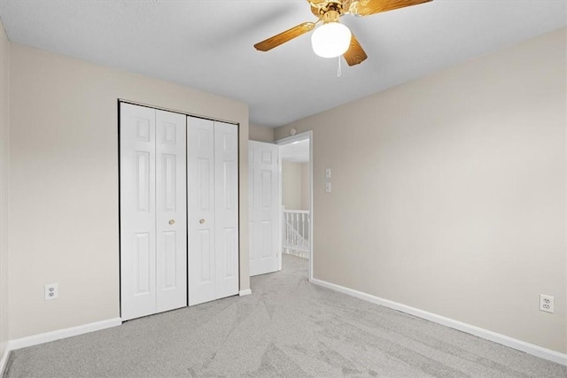 unfurnished bedroom with a closet, ceiling fan, and light colored carpet