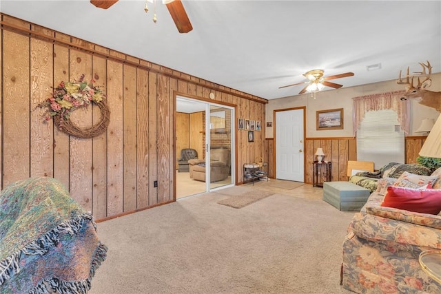 living room featuring ceiling fan, light carpet, and wooden walls