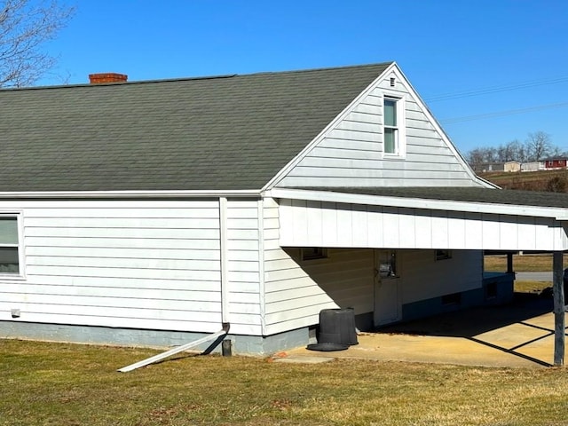 view of side of home with a lawn and a carport