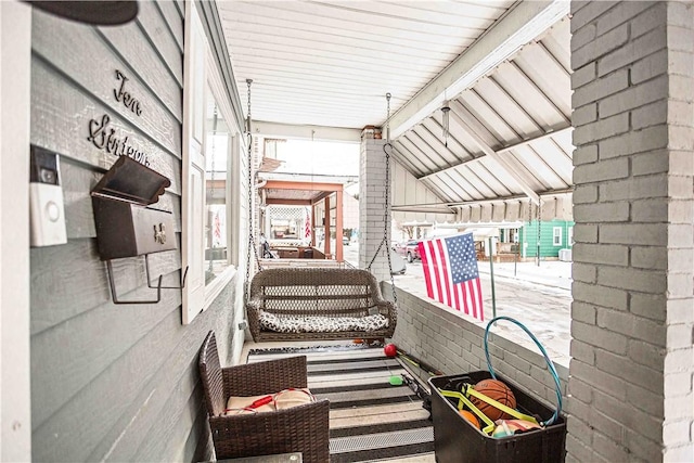 exterior space featuring lofted ceiling and brick wall