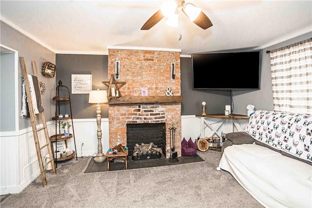 living room with a brick fireplace, ceiling fan, carpet floors, and ornamental molding