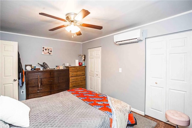 bedroom with a closet, an AC wall unit, ceiling fan, crown molding, and hardwood / wood-style flooring