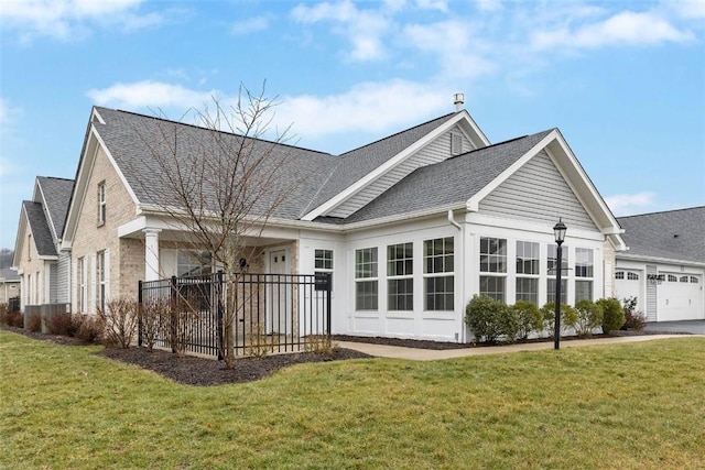 rear view of house featuring a yard and a garage