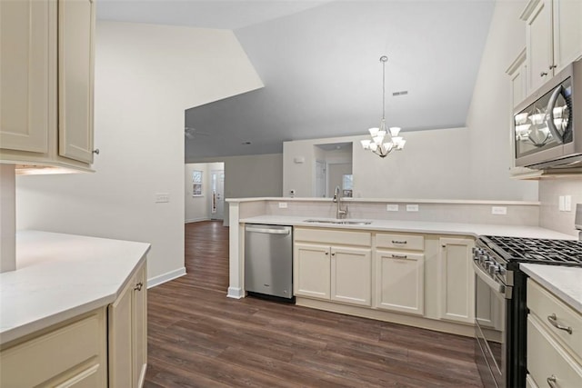 kitchen with sink, dark hardwood / wood-style floors, decorative light fixtures, stainless steel appliances, and cream cabinets