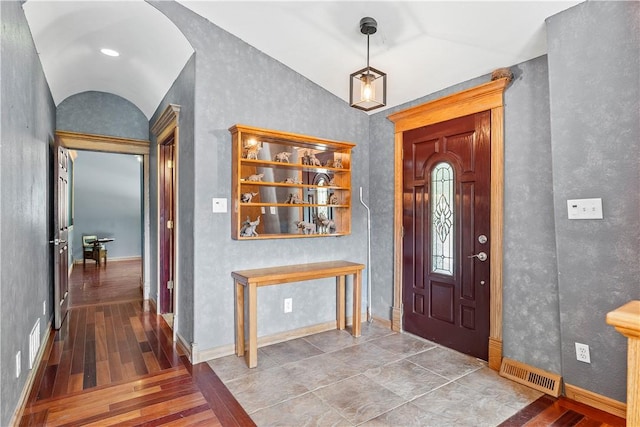 foyer entrance featuring hardwood / wood-style flooring and vaulted ceiling