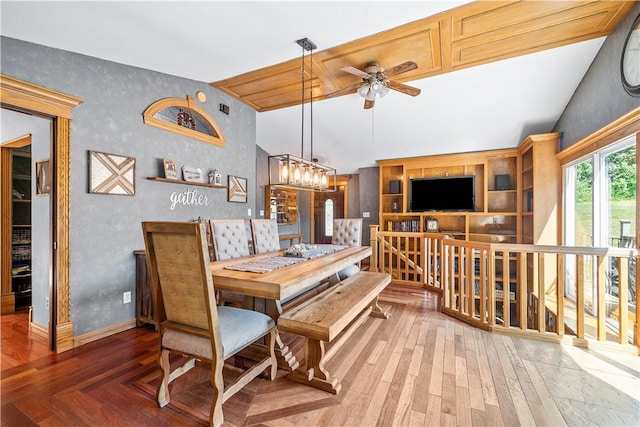 dining area featuring vaulted ceiling, dark hardwood / wood-style floors, and ceiling fan with notable chandelier