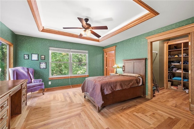 bedroom featuring light parquet flooring, a raised ceiling, and multiple windows