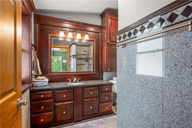 bathroom featuring lofted ceiling, vanity, tile patterned flooring, and a shower