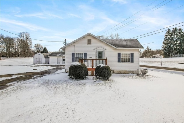 view of front of home with a deck and a storage shed