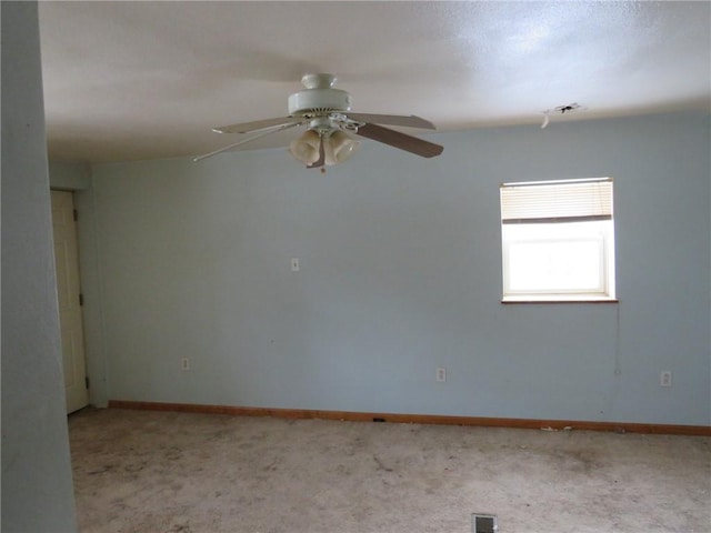 spare room with light carpet, ceiling fan, visible vents, and baseboards