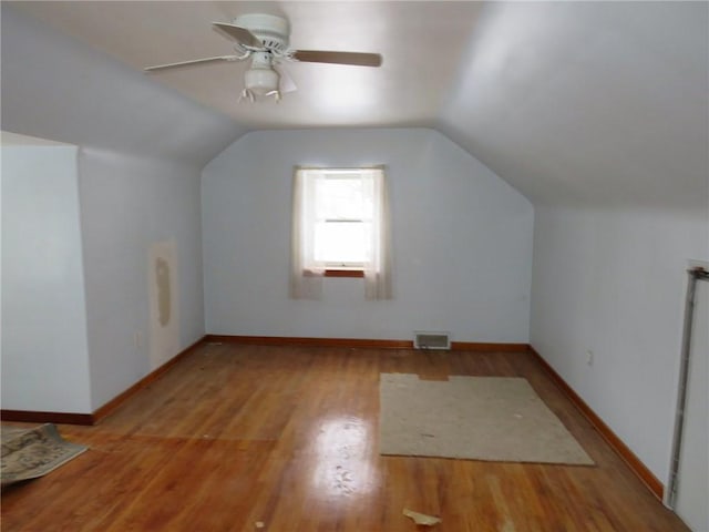 bonus room with lofted ceiling, light wood finished floors, baseboards, and visible vents