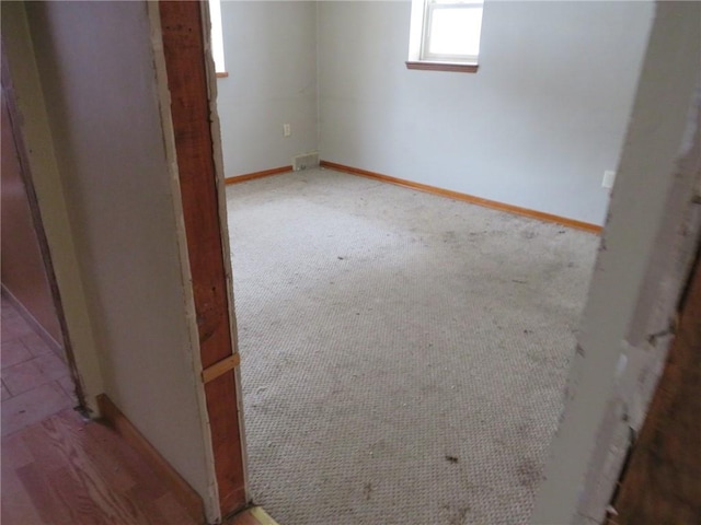 unfurnished room with baseboards