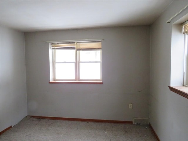 spare room featuring carpet flooring and baseboards