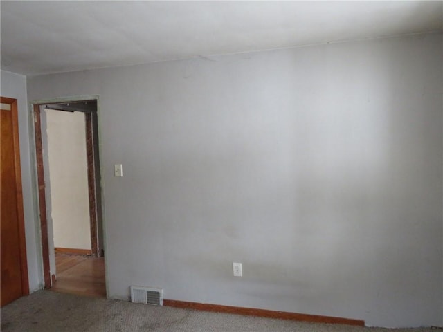 carpeted spare room featuring visible vents