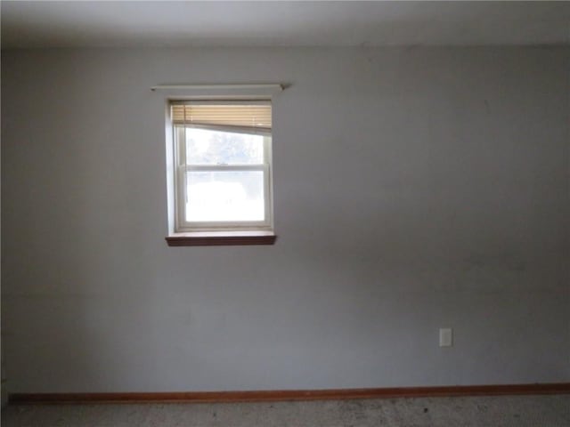 empty room featuring carpet flooring and baseboards