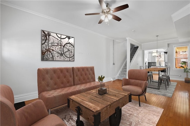 living room featuring hardwood / wood-style floors, ceiling fan, and ornamental molding