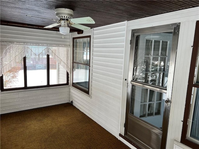 unfurnished sunroom with a ceiling fan