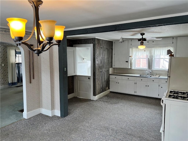 kitchen with wallpapered walls, a sink, a notable chandelier, and white appliances