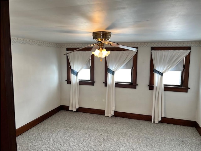 unfurnished room with baseboards, light carpet, a ceiling fan, and plenty of natural light