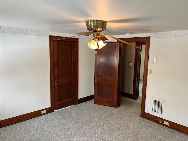 unfurnished room featuring visible vents, light carpet, baseboards, and ceiling fan