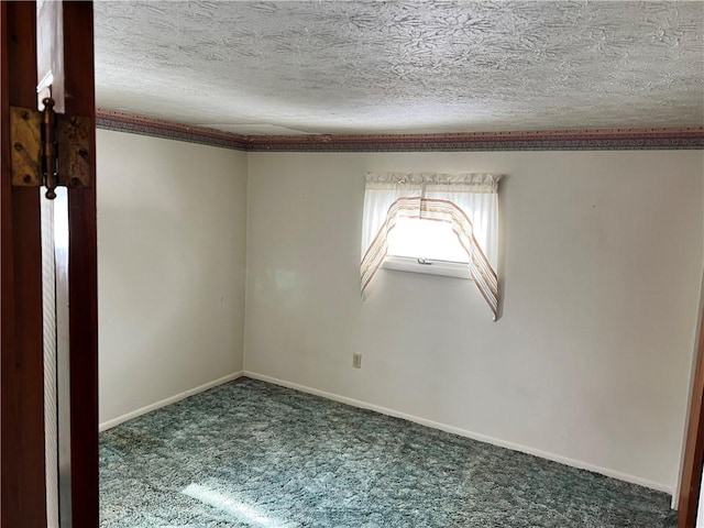 carpeted spare room featuring baseboards and a textured ceiling