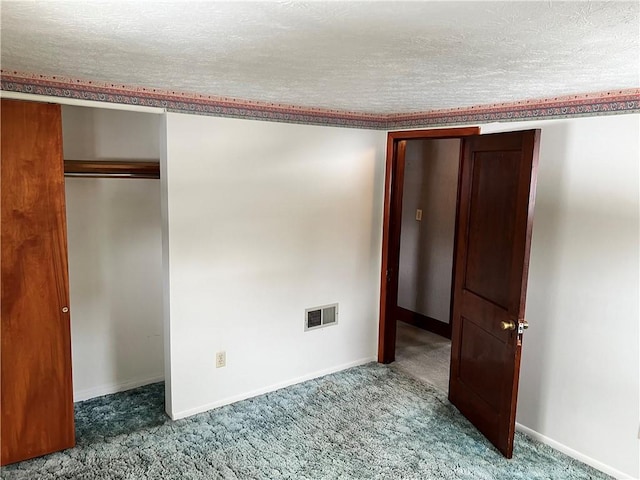 unfurnished bedroom featuring baseboards, visible vents, carpet flooring, and a textured ceiling