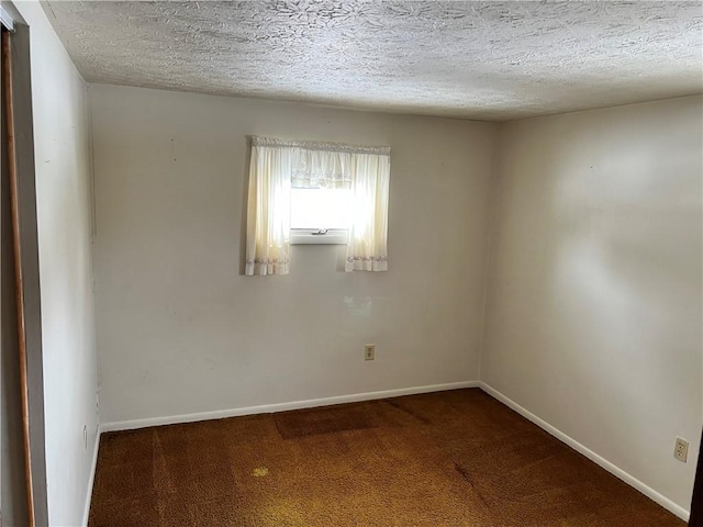 carpeted empty room with baseboards and a textured ceiling